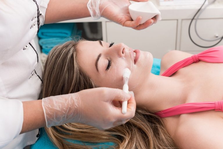 Woman having a facial massage and peeling in beauty salon